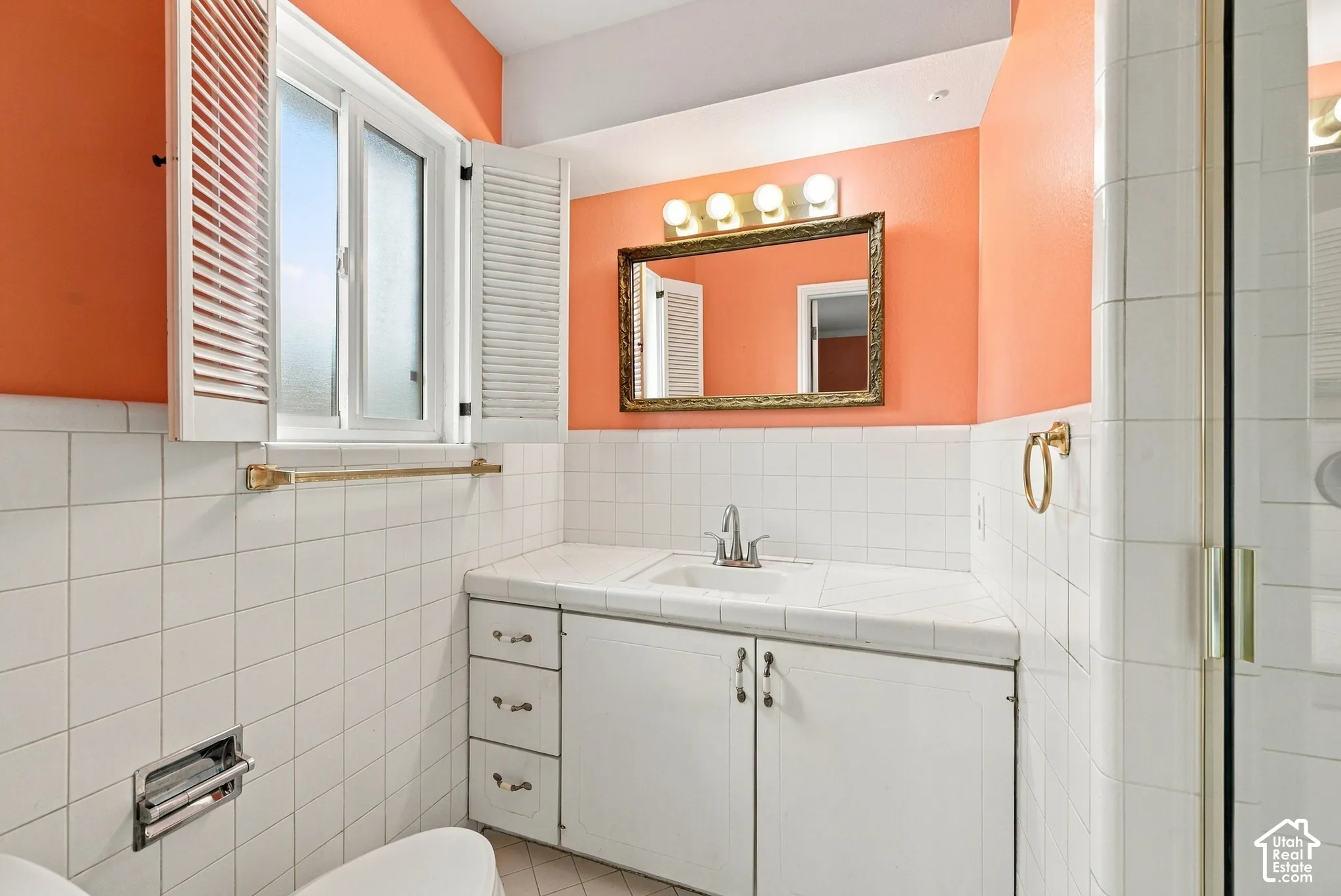 Ensuite Bathroom Vanity featuring a tiled countertop with an integrated basin, white cabinetry