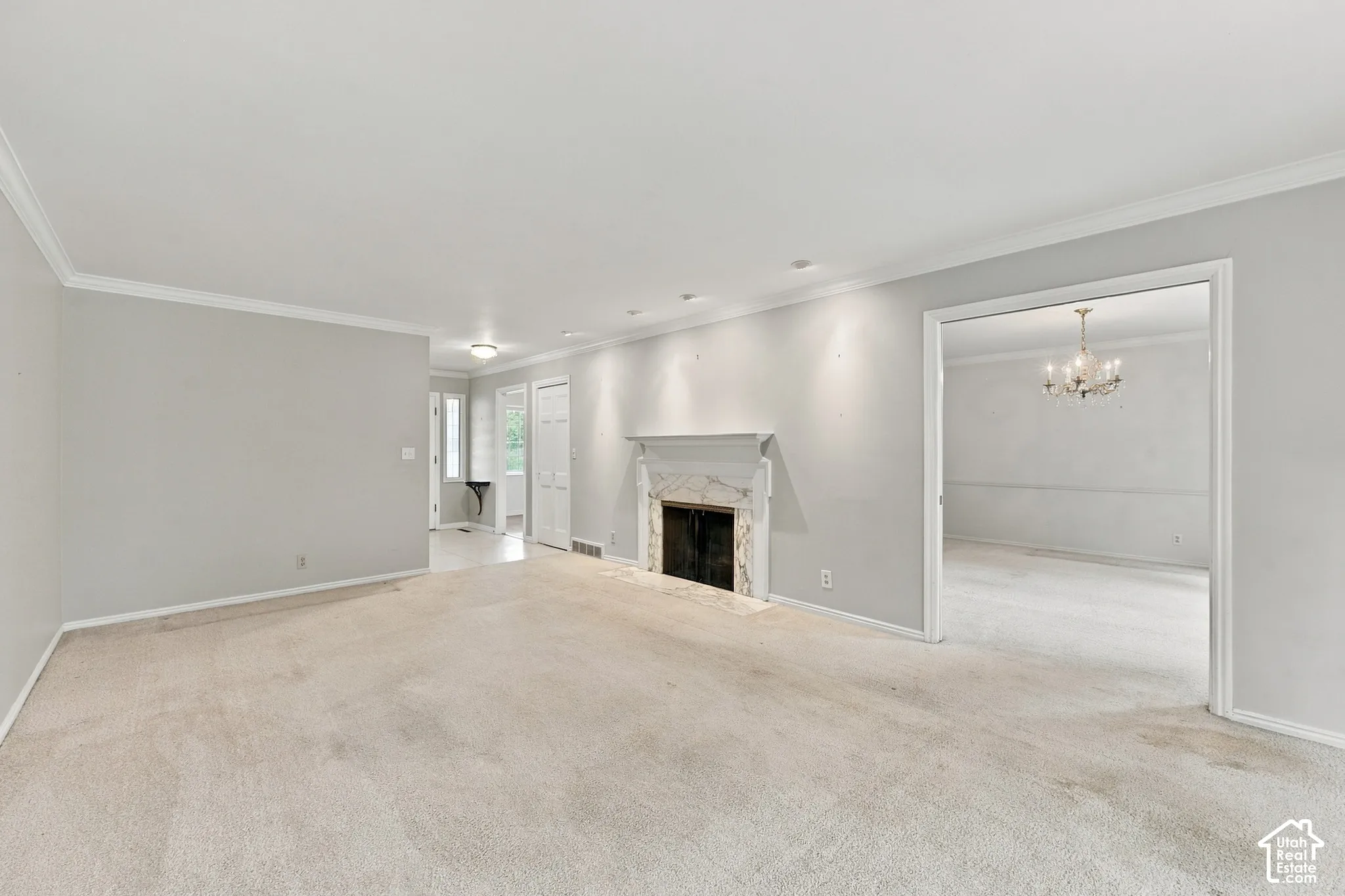 Fireplace with a stone-surround mantel, recessed lighting, and crown molding
