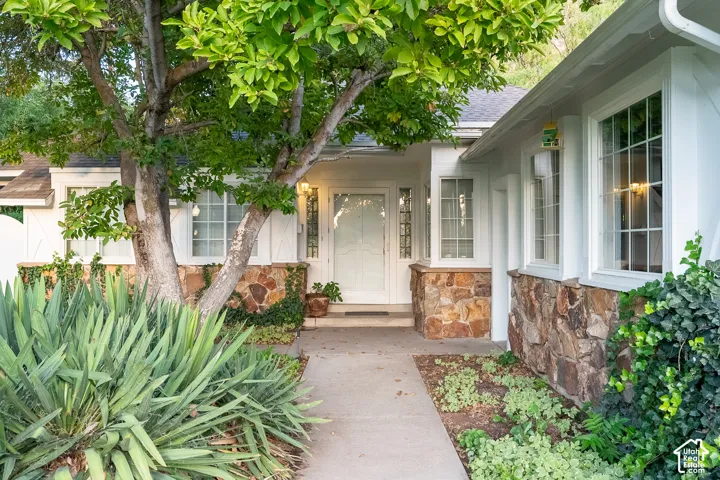 Stone siding accents a white exterior with multiple bay windows and a full-light entry door