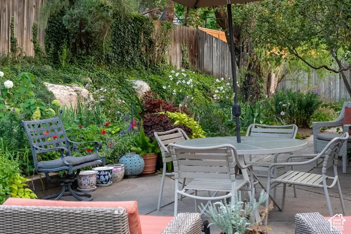 Outdoor patio bordered by lush landscaping and a privacy fence