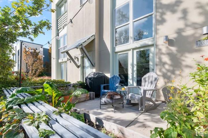 Patio with concrete slab, wall-mounted exterior lighting, and French doors