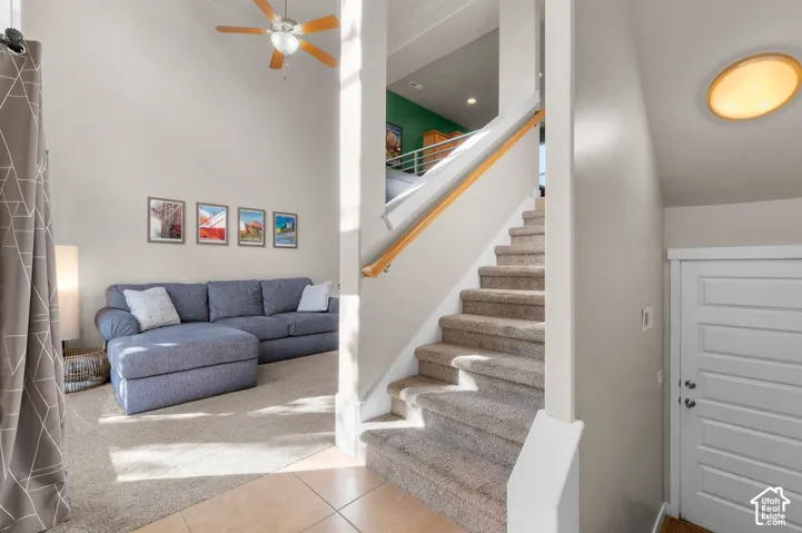 Two-story interior with a carpeted staircase and tile flooring