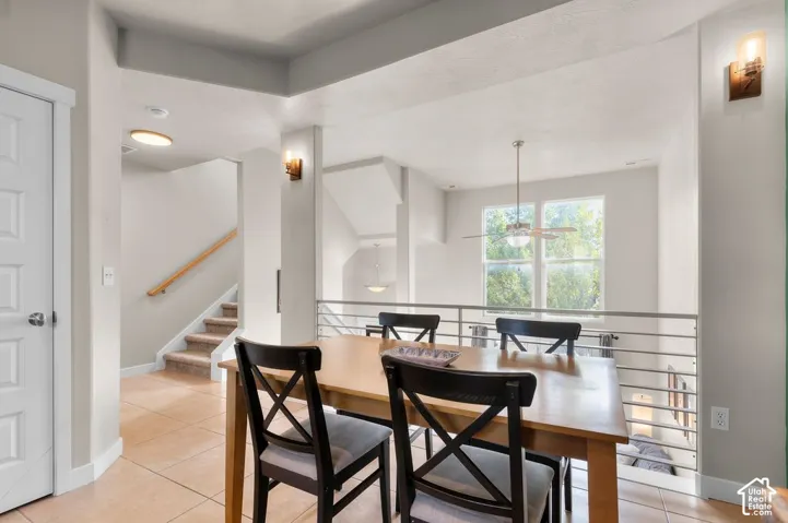 Tiled flooring, vaulted ceiling, large windows, and an open railing system