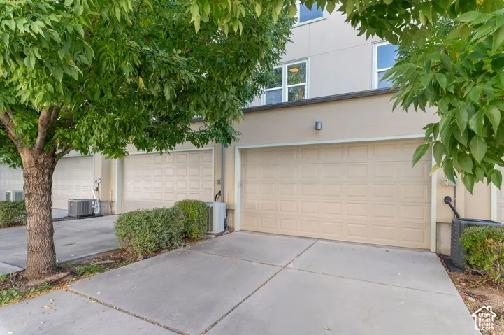 Concrete driveway leading to a patterned garage door