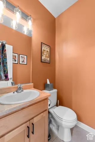 Vanity with light wood-finish cabinetry, integrated sink, and chrome faucet