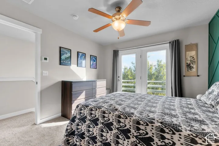 Double patio doors providing abundant natural light, ceiling fan with integrated lighting, and carpeted flooring