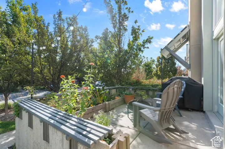 Concrete patio with an adjacent raised garden bed and built-in seating