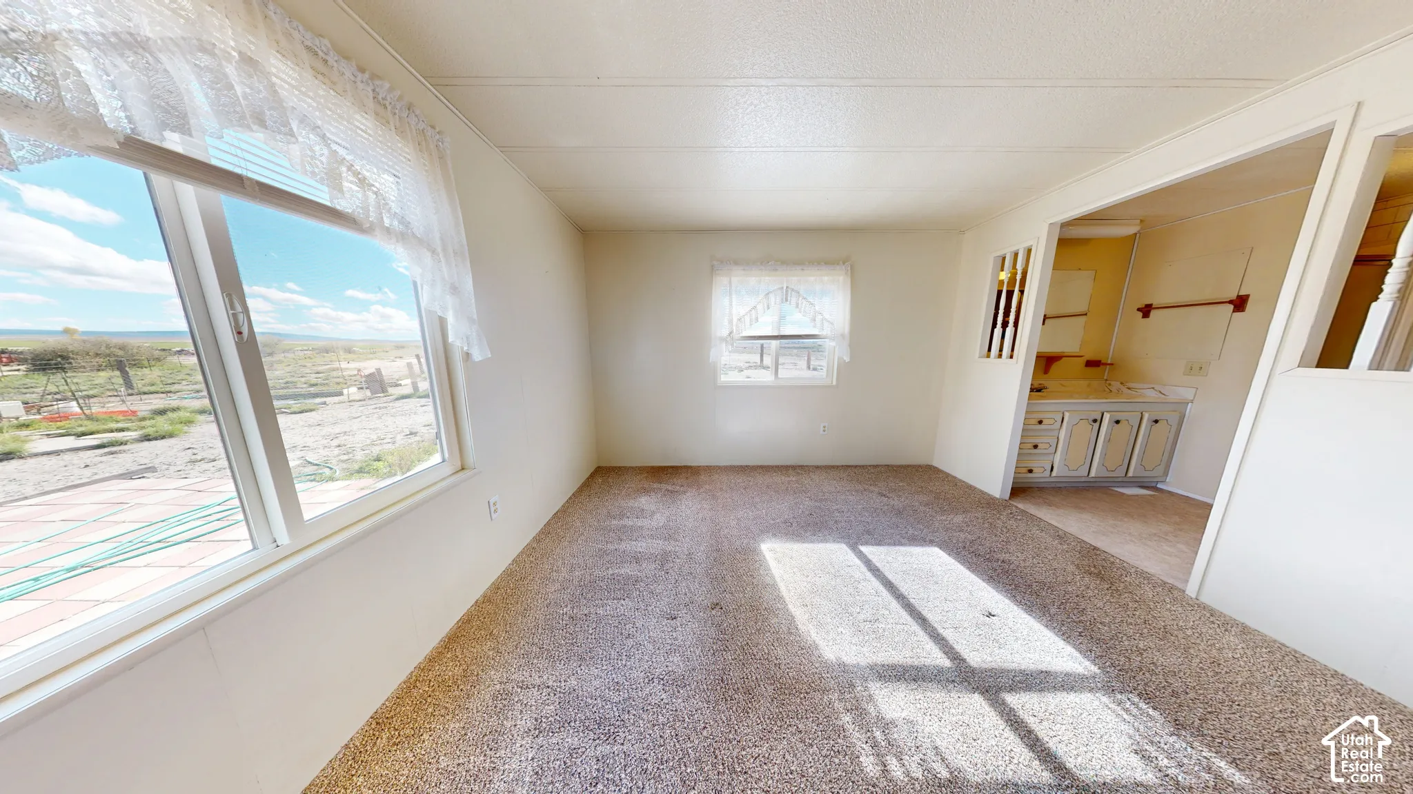 Interior space featuring wall-to-wall carpeting, dual windows, and an integrated vanity area with built-in cabinetry