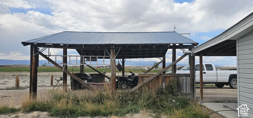 Covered outdoor structure with a corrugated metal roof and exposed wood framing
