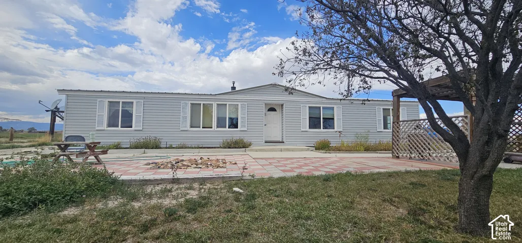 Light gray siding exterior with white window trim and shutters, complemented by a white entry door