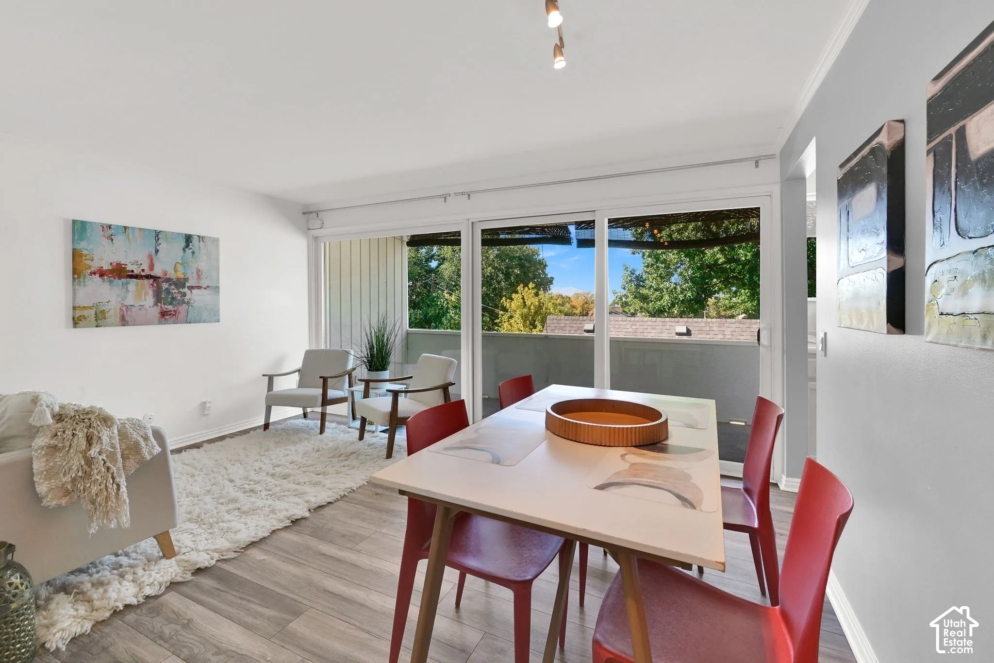 Wood-finish flooring, white walls, sliding glass door, and track lighting