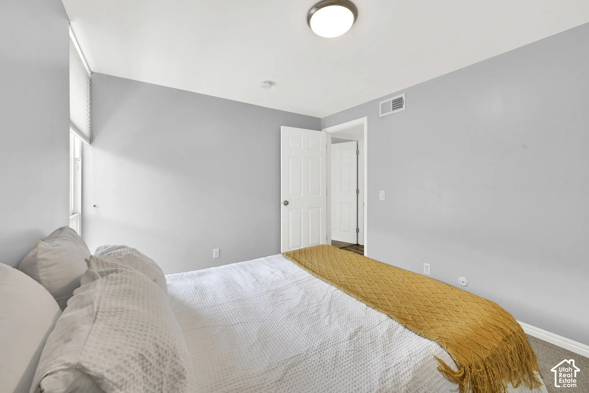 Recessed window with roller blinds, light gray wall paint, and overhead flush-mount lighting