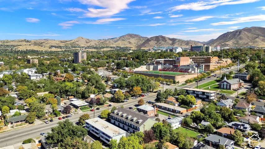 Expansive neighborhood with mature trees, established residential buildings, and a mountainous backdrop
