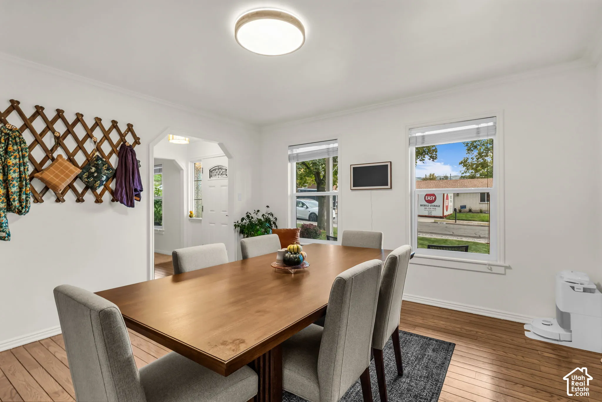 Wood-finish flooring, white walls, and a contemporary flush-mount ceiling light
