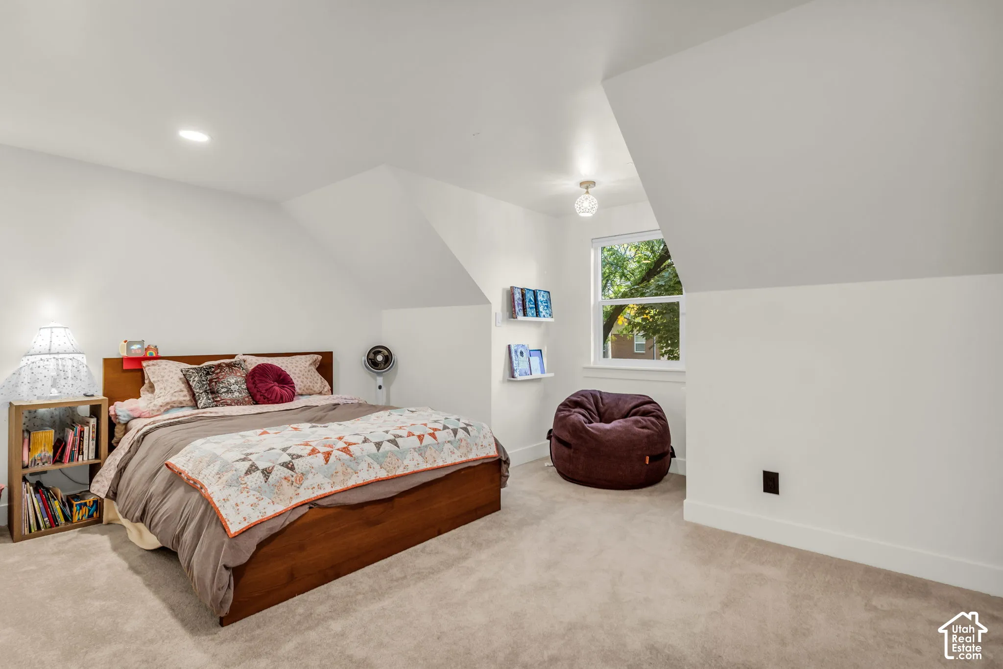Carpeted room with sloped ceilings, recessed lighting, and a large window