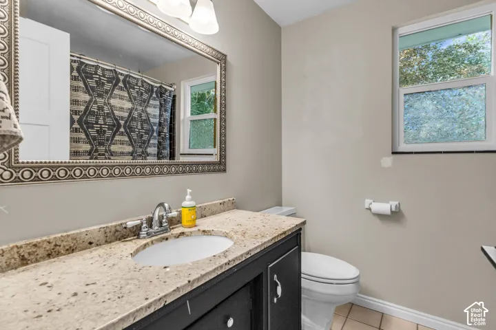 Vanity with a granite countertop, undermount sink, and chrome faucet