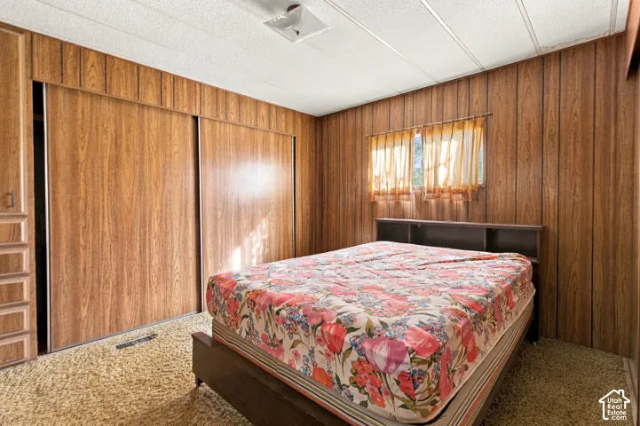 Wood-finish wall paneling, built-in shelving, sliding closet doors, and textured ceiling panels