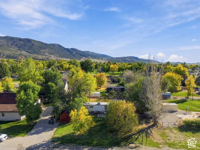 Mountain backdrop with expansive sky, surrounded by mature trees