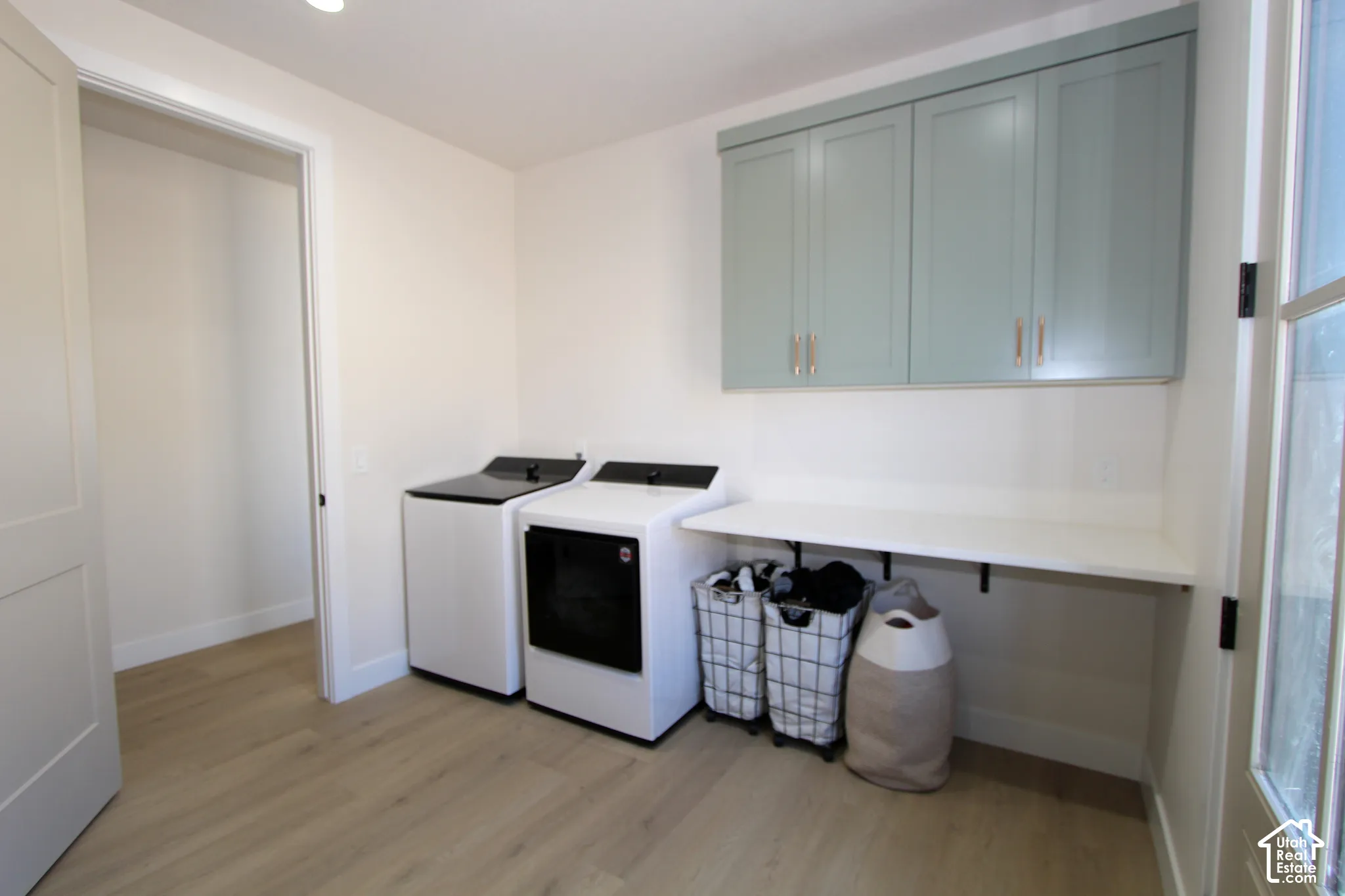 Built-in shelving with light blue cabinetry, wood-finish flooring, and a white countertop