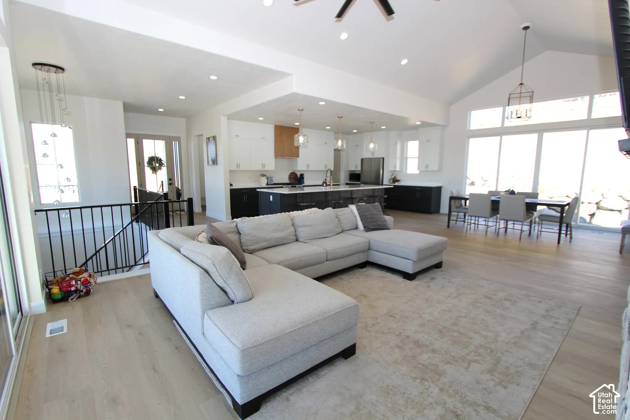 Open-concept living area featuring a vaulted ceiling and wood-finish flooring