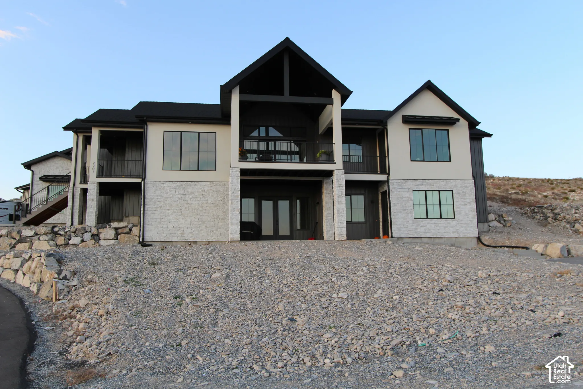 Multi-level exterior with light-toned stucco and contrasting dark vertical siding