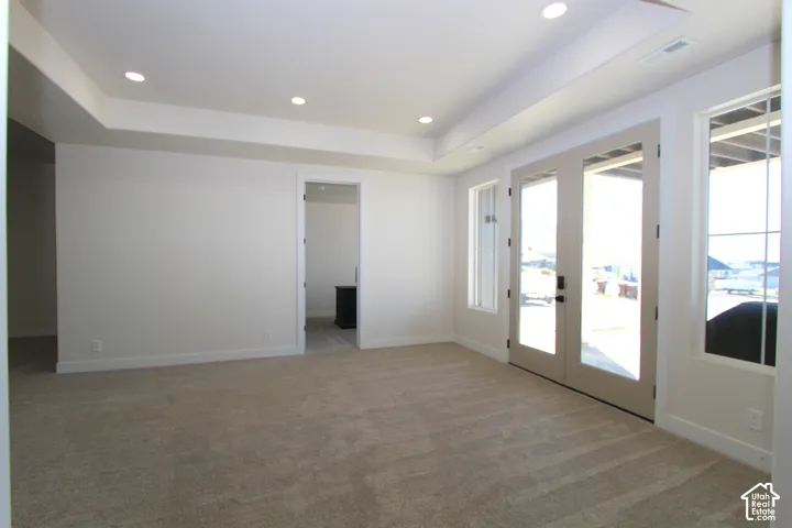 Recessed lighting, light-colored walls, carpeted flooring, French doors, and transom windows