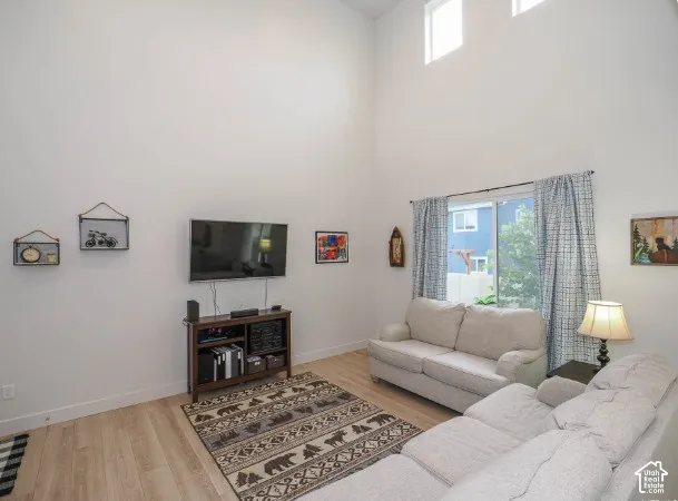 High ceilings with upper transom windows, light wood-finish flooring, and a sliding glass door