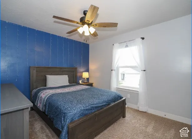 Wall-mounted ceiling fan, single window with white trim, and light-colored carpeting