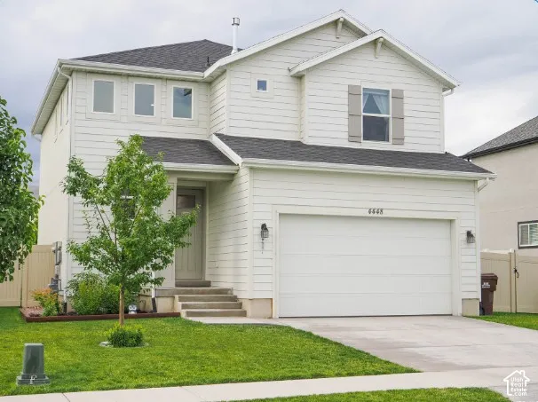 Two-story residence featuring white siding, a dark shingle roof, and an attached two-car garage