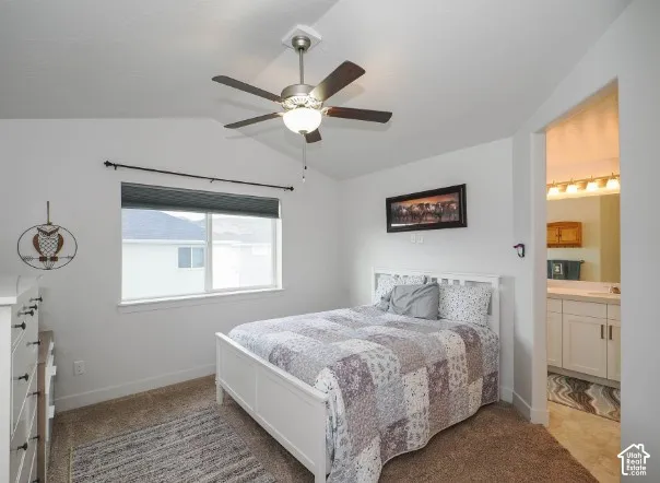 Vaulted ceiling with a ceiling fan, neutral wall paint, and a built-in window