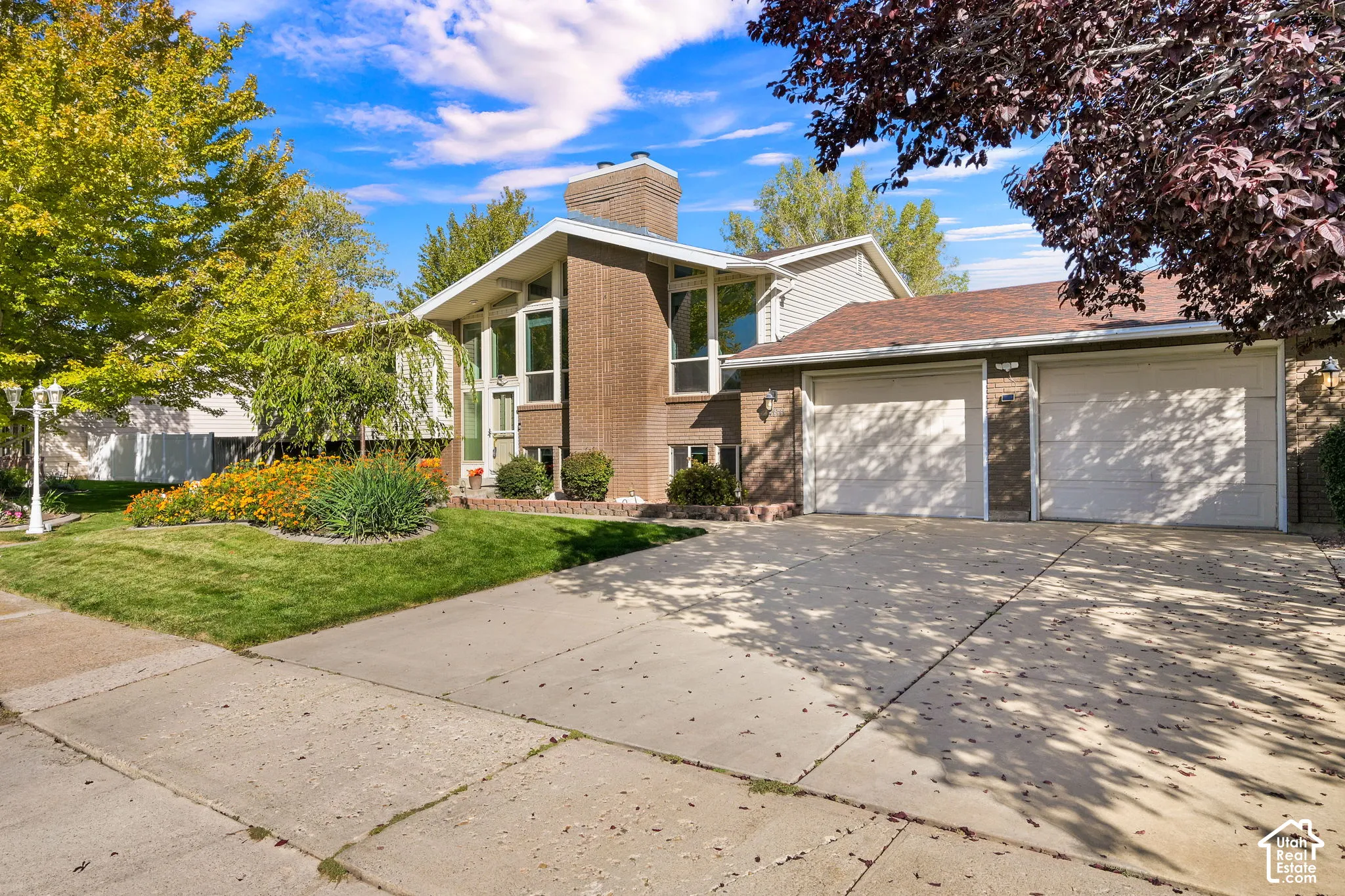 Brick exterior with vertical windows, an attached two-car garage, and a concrete driveway