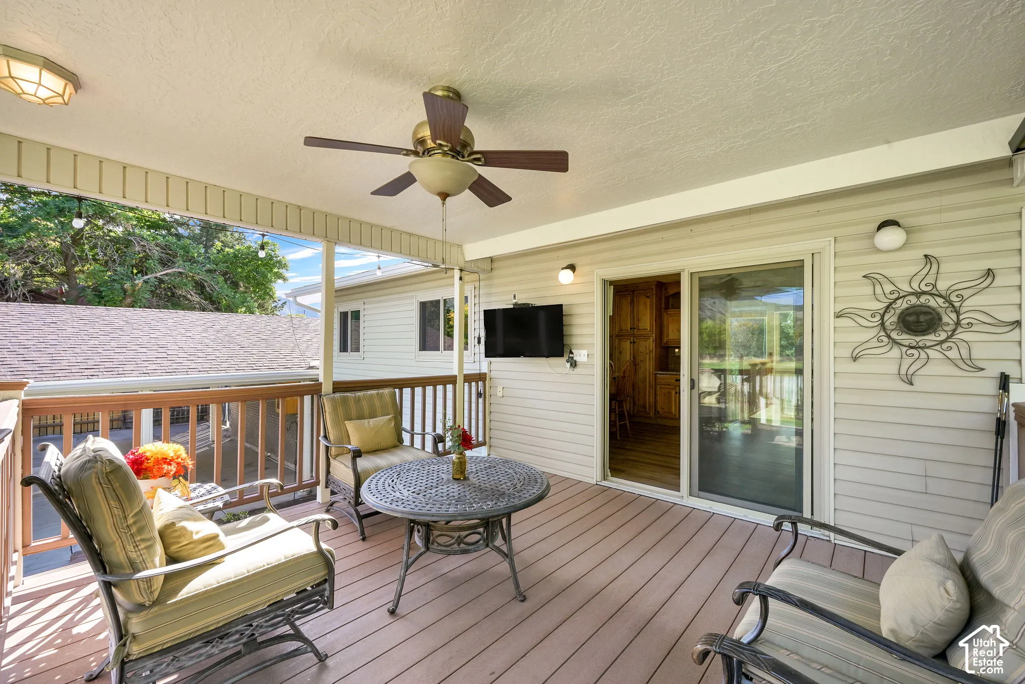 Covered outdoor deck with ceiling fan, recessed lighting, and wood-finish flooring
