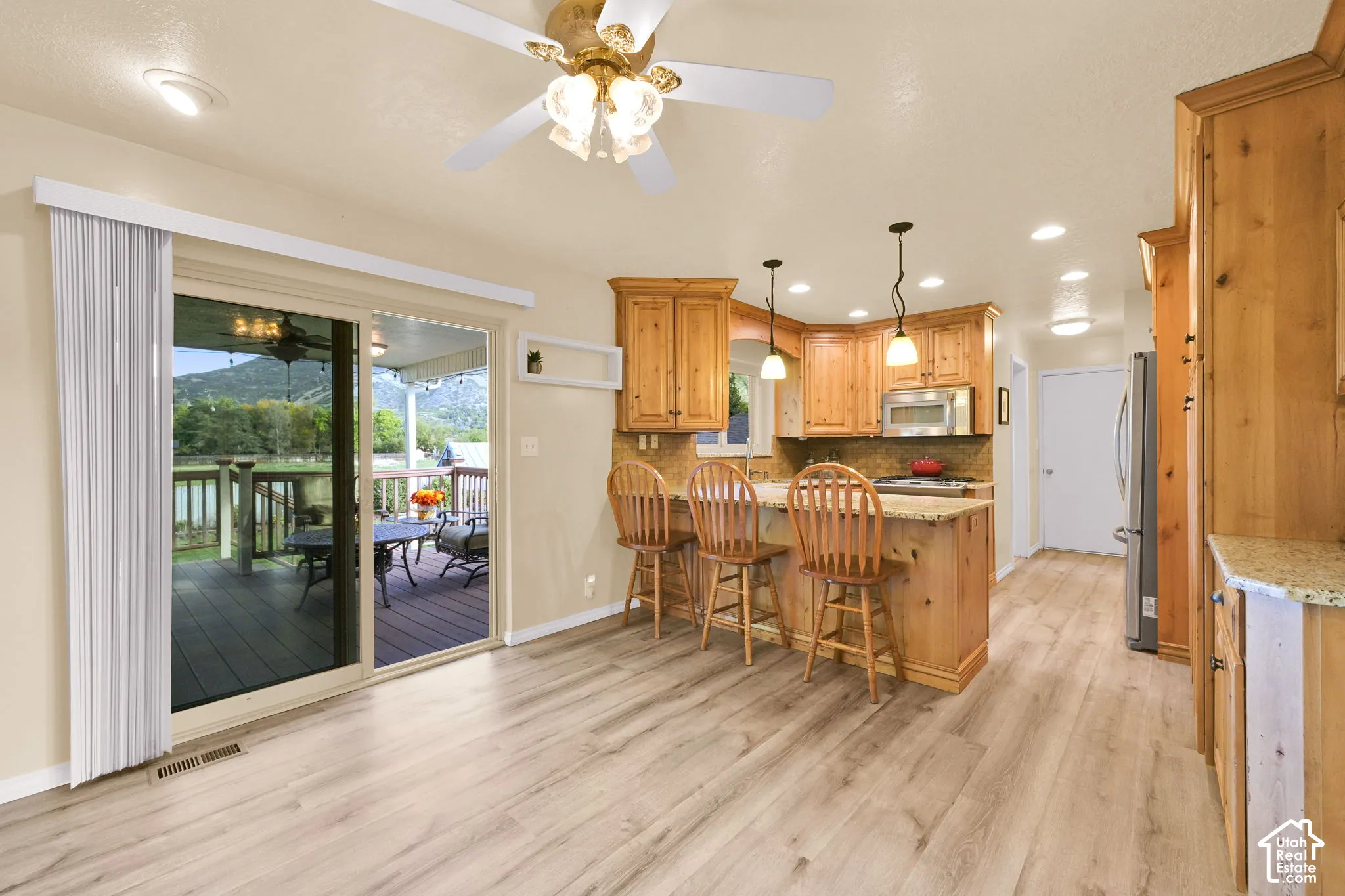 Wood-finish flooring, recessed lighting, and a ceiling fan with light fixture