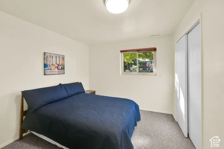 Bedroom 5. Carpeted flooring, white walls, and a window