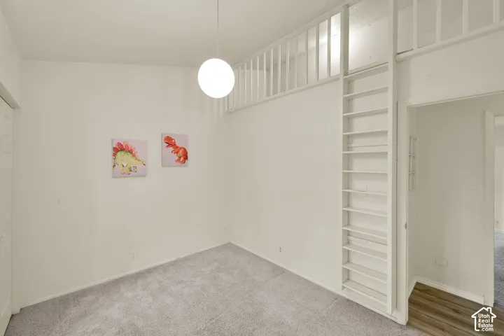 Bedroom 3. Loft area with open balustrade, suspended globe light fixture, and carpeting
