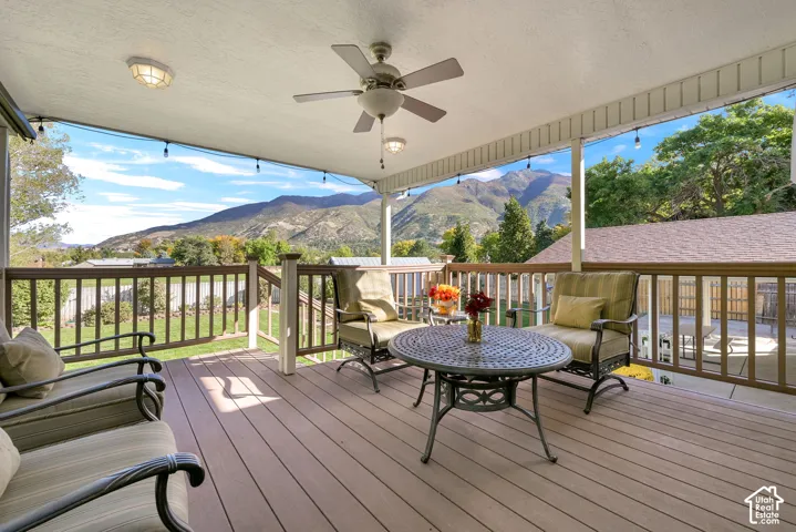 Covered deck off dining room with composite decking, a ceiling fan, recessed lighting, and a wooden railing