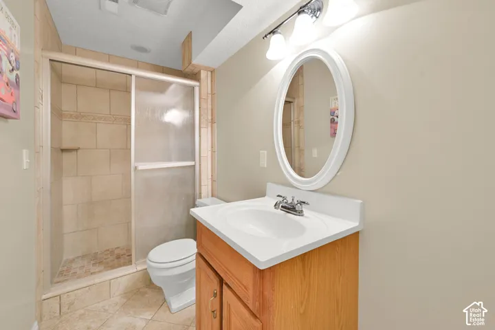 Basement bathroom. Tiled shower enclosure with a glass sliding door