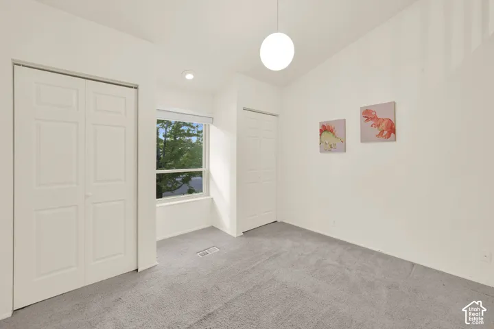 Bedroom 3. Vaulted ceiling with recessed lighting and a suspended globe fixture