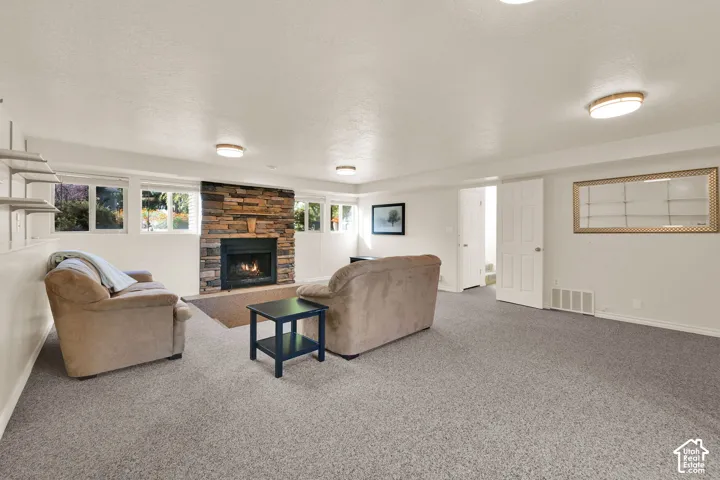 Basement living room, Stone-faced fireplace with hearth, multiple windows, and recessed lighting