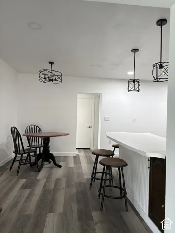 Wood-finish flooring, recessed lighting, and modern pendant lights