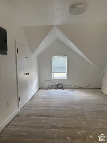 Window with blinds, wood-finish flooring, recessed lighting, and a built-in closet
