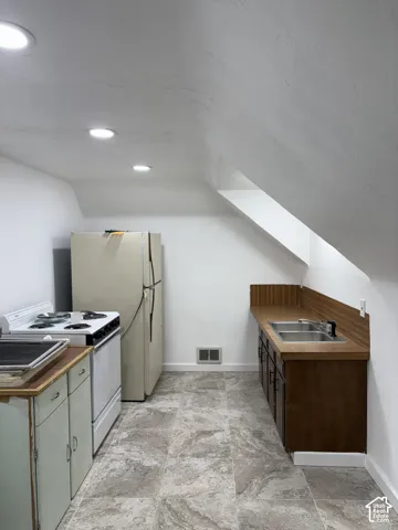 Kitchenette featuring recessed lighting, a dual basin stainless steel sink, wood-finish countertops, and tile flooring