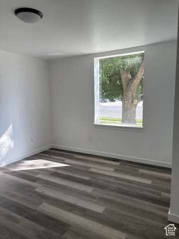 Wood-finish flooring, white trim, recessed window, and flush-mount ceiling light
