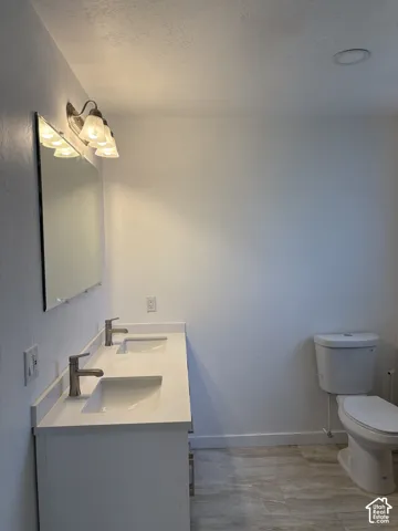 Dual vanity with integrated sinks, brushed nickel faucets, and a full-width mirror