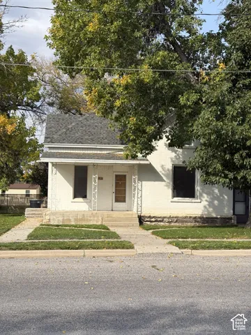 Front exterior featuring a covered porch, white siding, and a gabled roof