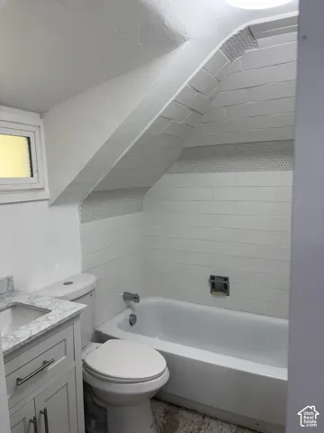 White subway tile shower surround with a mosaic accent band, white bathtub, and a modern vanity with a stone countertop