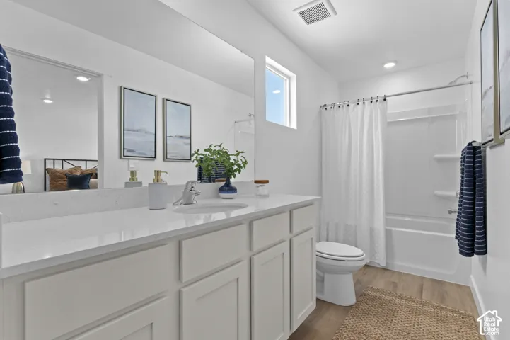 White vanity with an integrated sink, quartz countertop, and large wall-mounted mirror