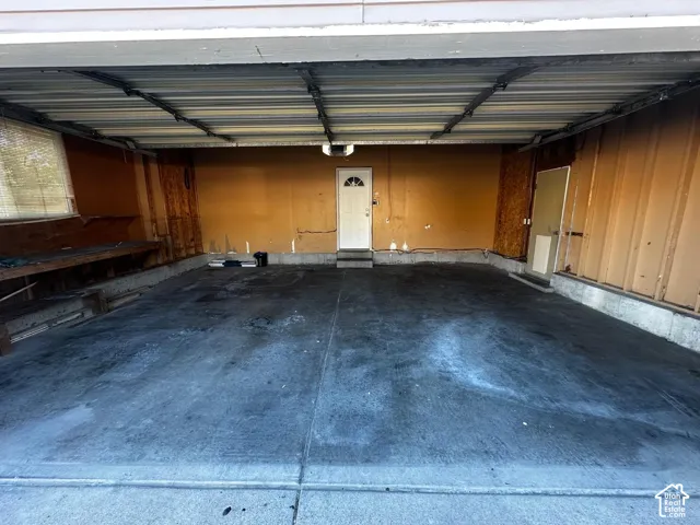 Multi-car garage featuring a concrete floor, overhead door, built-in workbench, and two exterior access doors