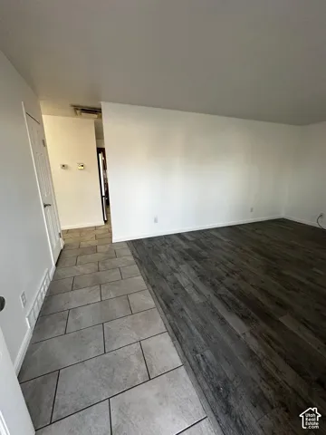 Interior space featuring neutral wall paint, wood-finish flooring, and large-format ceramic tile flooring