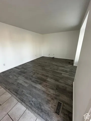 Room featuring wood-finish flooring and neutral-toned wall paint